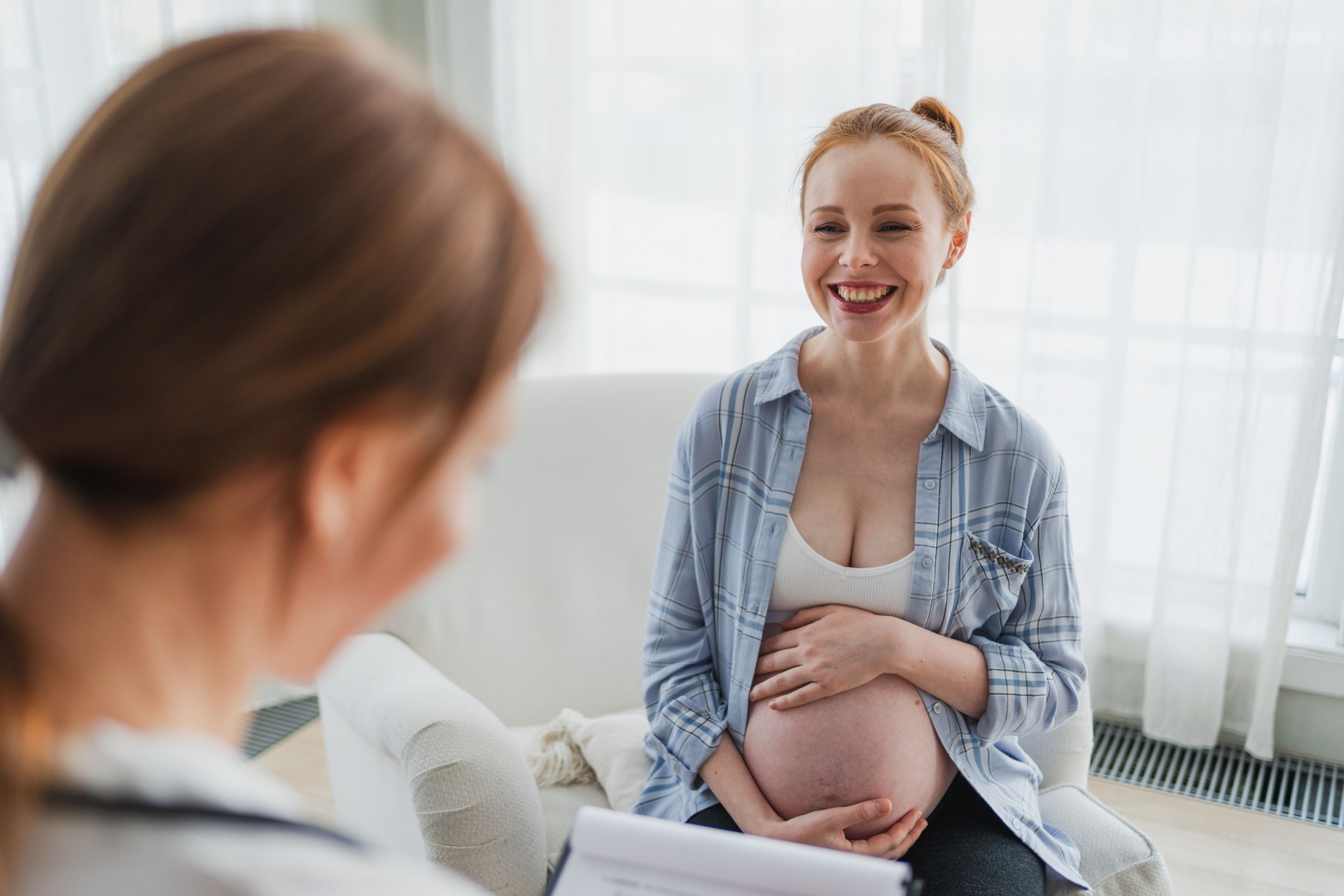 Female doctor examining pregnant woman in doctor office. Pregnant girl patient have consultation in hospital. Gynecologist doctor consulting patient about pregnancy. Visit to doctor medical checkup.