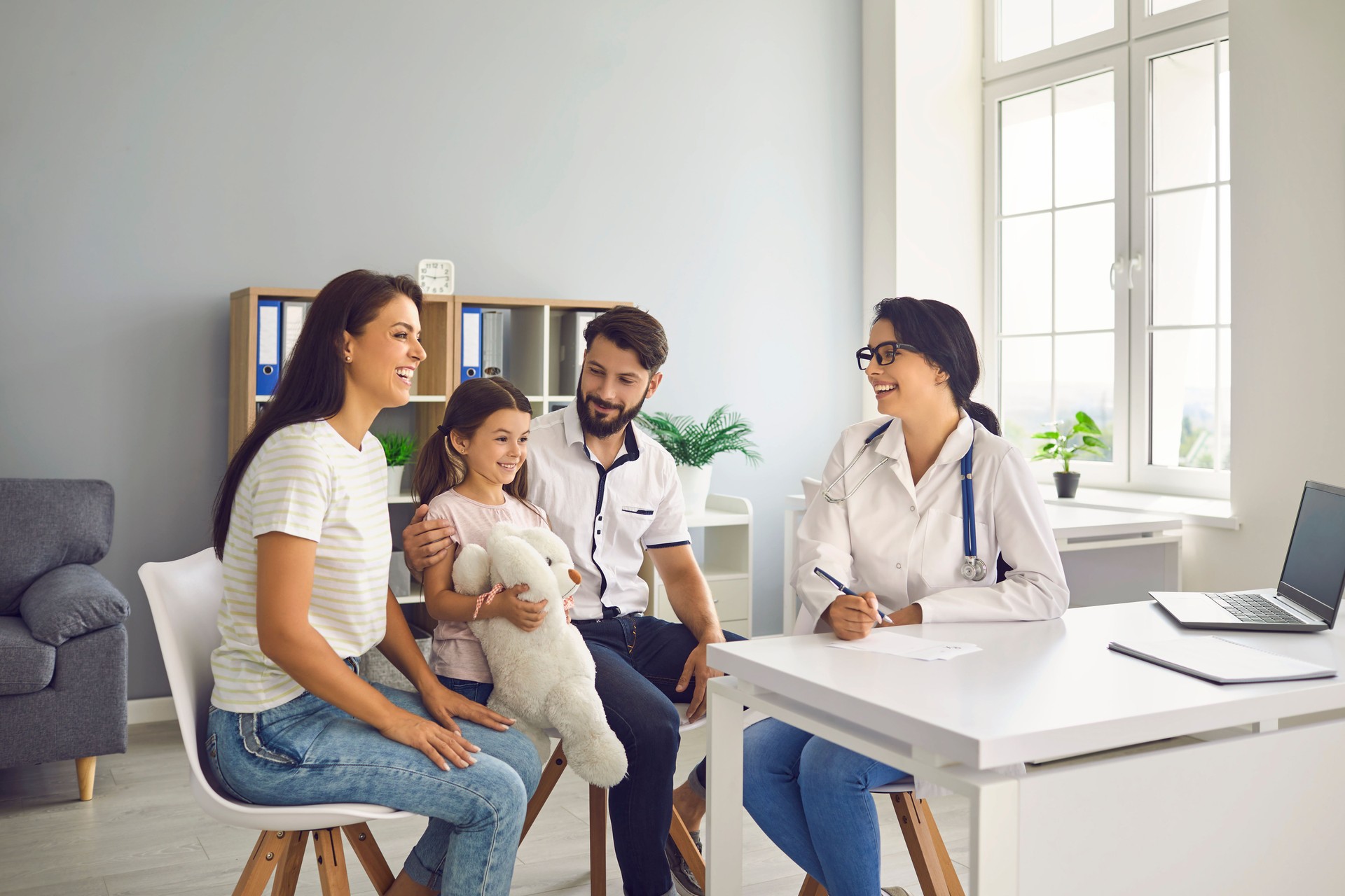 Family doctor at the clinic. Mother father and child on consultation with a pediatrician in the office.